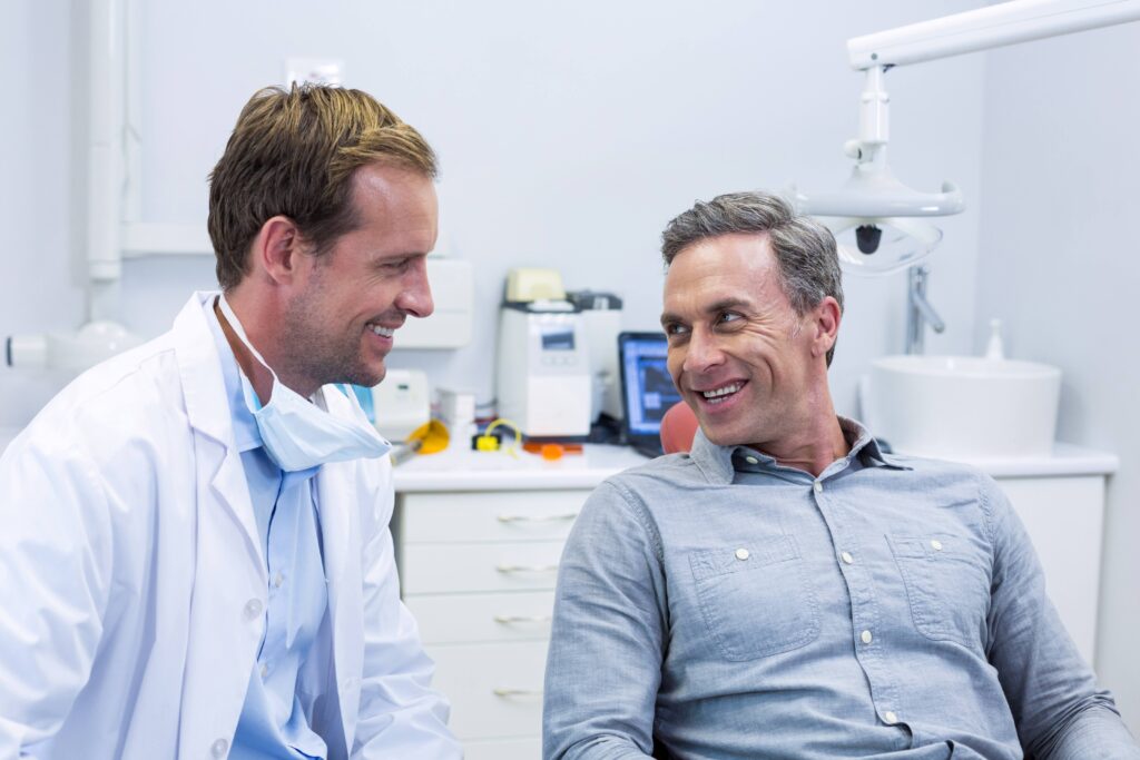 Smiling patient talking to dentist at consultation