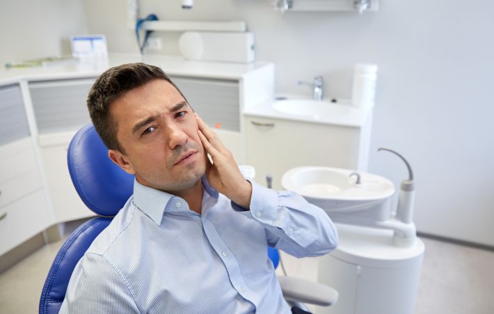 A man with a toothache in a dentist’s chair